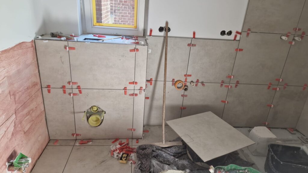 Beginn der Fliesenarbeiten an der Wand mit Nivelliersystem in Stuttgart