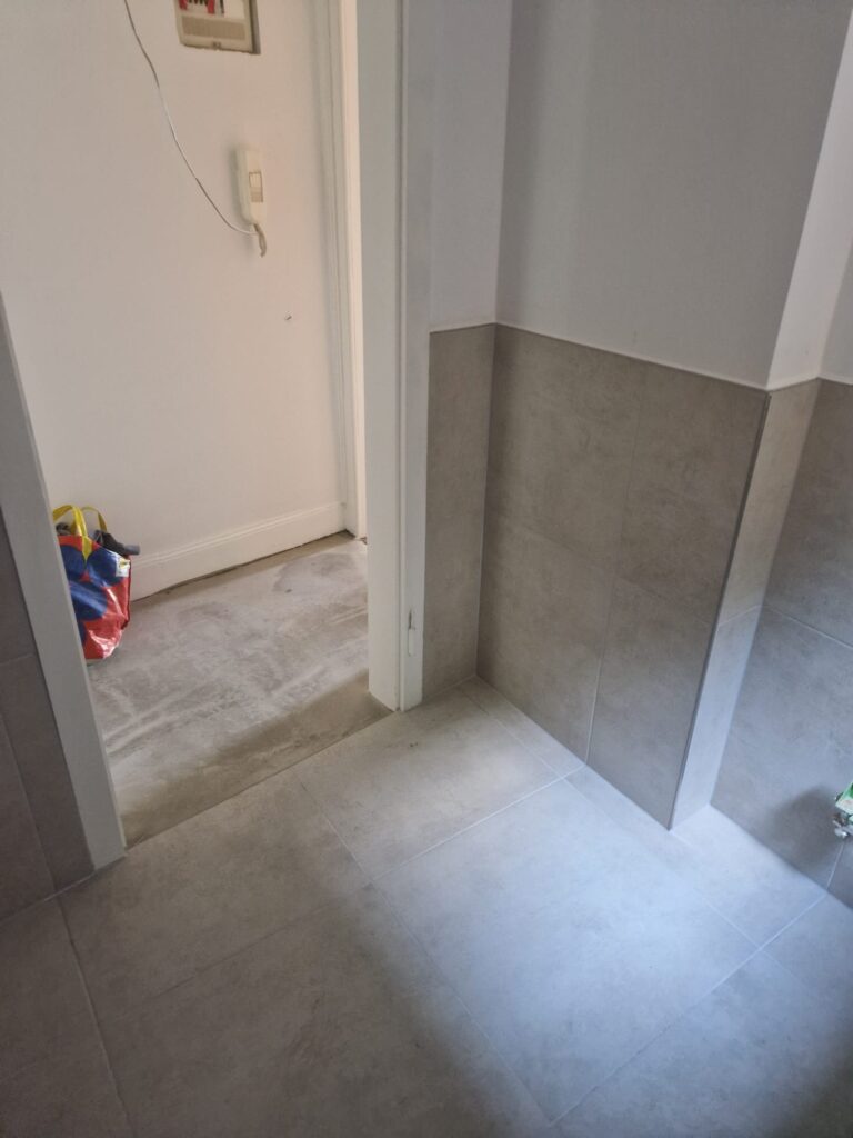 Gefliester Übergang zwischen Flur und Bad nach der Sanierung in Stuttgart
